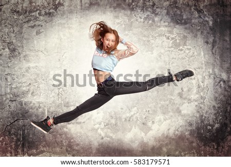 Young woman modern ballet dancing on wall background