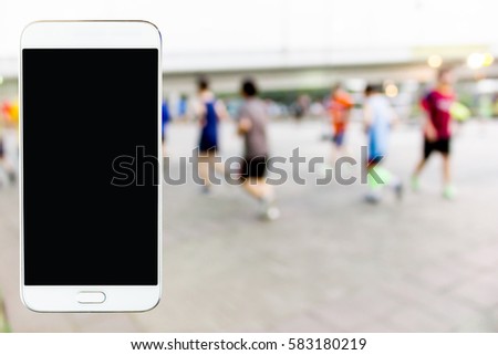 Mobile phone with blurred image of people exercising in the park as background.