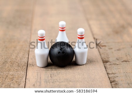 Toy bowling ball and pins isolated on a wood background