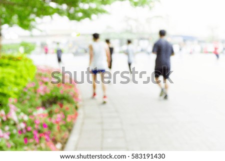 blurred image of people exercising in the park as background.