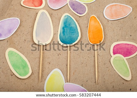 Set of watercolor eggs for baking decoration made of paper on craft background