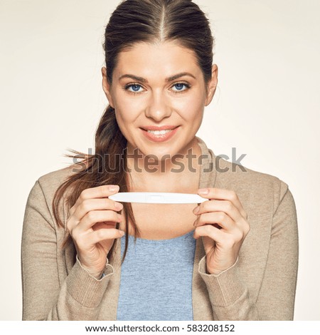 Young smiling woman holding pregnant test. Isolated portrait.