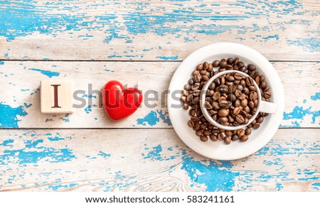 I love coffee. Cup with coffee beans with heart on wooden background. 