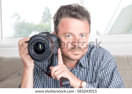 Happy Good Looking Male Photographer Taking Picture Using DSLR While Facing at the Camera.