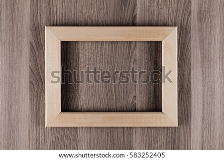 Blank beige  wooden frame on brown surface board, mock up, top view. Interior.