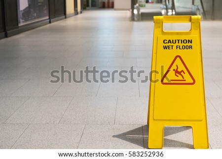 Wet floor caution sign on pathway in office