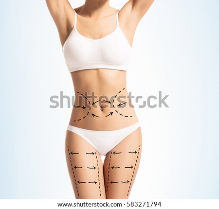Sporty girl with arrows on her body. Fat lose, sport, healthy eating, nutrition concept.