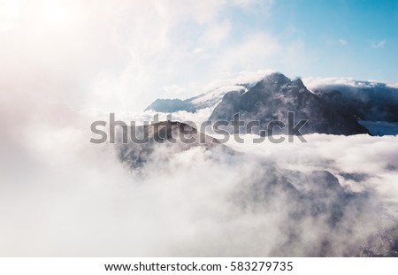 Creamy fog covered the famous glacier Marmolada in morning light. Picturesque and gorgeous scene. Location place Val di Fassa valley, passo Sella, Dolomiti, South Tyrol. Italy, Europe. Beauty world.