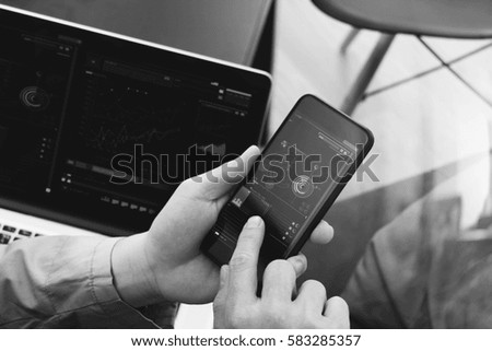 hand using smart phone and digital tablet computer for online banking payment communication in modern office,black and white