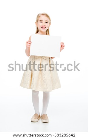 Excited little girl holding blank card an looking at camera isolated on white
