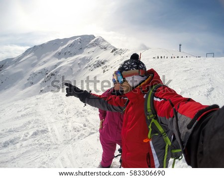 Skier shows to female something in distance on snowy mountain