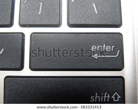 Close up of black Enter key on a modern white laptop 