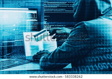 Internet crime concept. Hacker working on a code and stealing credit card with digital interface around. Royalty-Free Stock Photo #583338262