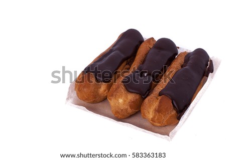 Sweet delicious three chocolate eclairs isolated on white. Traditional french cakes cooked from choux dough filled with a cream
