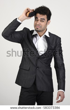 Man combing his hair with a shoe brush