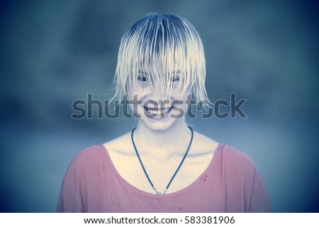 Portrait of a smiling girl with wet blond hair in red blouse. Toned