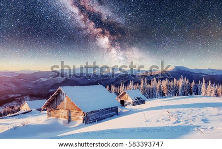 Chalets in the mountains at night under the stars. Magic event in frosty day. In anticipation of the holiday. Dramatic scenes. Carpathians Ukraine.