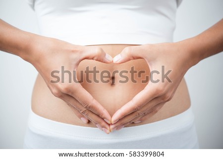 Close up of woman's hands made heart on belly isolated on white background.health care concept. Royalty-Free Stock Photo #583399804