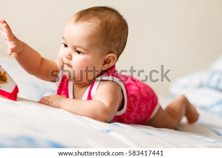 newborn on the bed with the children's book