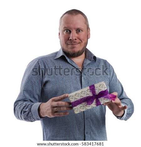 portrait of a emotional actor man in a gray shirt with a box with a gift in the hands posing on a white background in studio