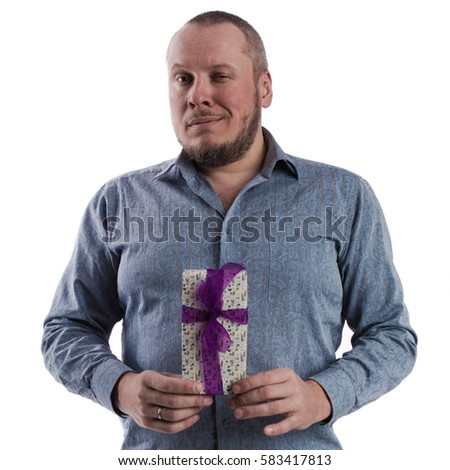 portrait of a emotional actor man in a gray shirt with a box with a gift in the hands posing on a white background in studio