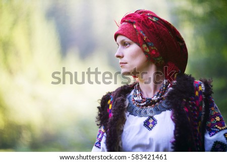 Young Ukrainian girl in an old picturesque present authentic national costume Ukrainian highlanders Gutsul on the background of wild nature Hutsulshchyna in Carpathians, Ukraine