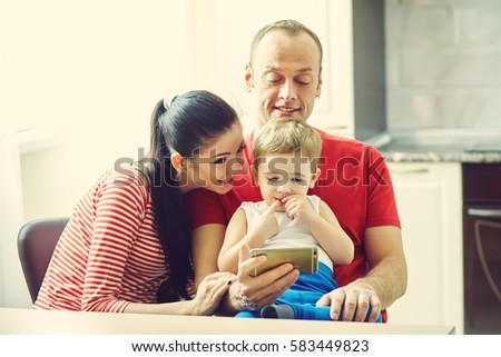 Family watching a cartoon on a tablet computer . Dad, mom and son at home