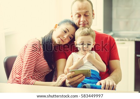 Family watching a cartoon on a tablet computer . Dad, mom and son at home