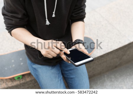 young skateboarder use cellphone at city skatepark