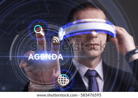 Business, Technology, Internet and network concept. Young businessman working in virtual reality glasses sees the inscription: Agenda