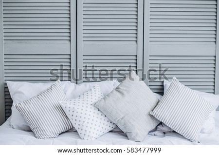 Four modern gray pillows on the big bed. Side view
