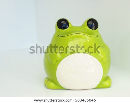 green frog piggy bank isolated background 