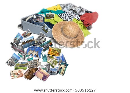 Studio shot of a suitcase with scattered clothing and straw hat. Photos of New York City landmarks are lying in front of the suitcase. Everything is on a white background.