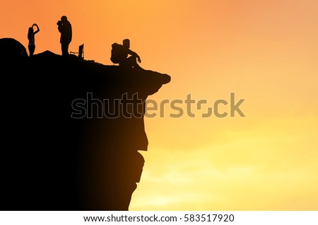 Hiking tourists standing on the rock ,beautiful mountain view, sunset background ,backpack silhouette