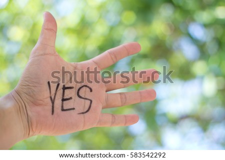Concept Photo Of A Handwriting Word "YES" On The Left Hand With Blurry Background