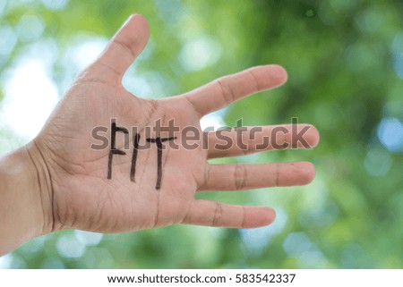 Concept Photo Of A Handwriting Word "FIT" On The Left Hand With Blurry Background