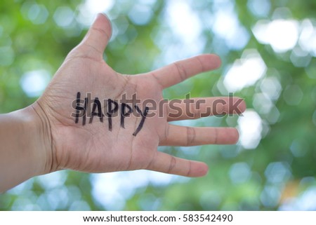 Concept Photo Of A Handwriting Word "HAPPY" On The Left Hand With Blurry Background