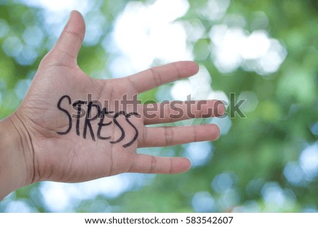 Concept Photo Of A Handwriting Word "STRESS" On The Left Hand With Blurry Background