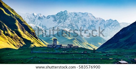 Summer panorama with ancient Lamaria church in Ushguli village. Majestic morning view of Shkhara mountains in Upper Svaneti. Caucasus mountains, Georgia, Europe. Artistic style post processed photo.
