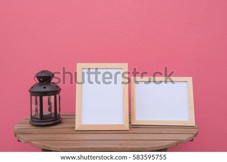 photo Frame on a wooden and Lantern on pink background .