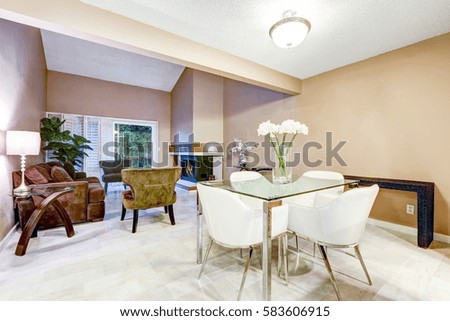 Chic dining area features modern glass table with white leather chairs. Connected to living room. Northwest, USA