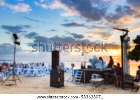 Blur background photo of wedding ceremony beside sea with a lot of guests in Thailand