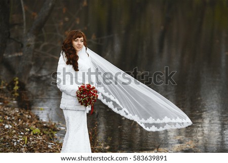 Beautiful bride in wedding dress and veil lace in nature. Beautiful girl model in white wedding dress. Cute lady outdoors. Portrait of woman in park. Woman with hairstyle.