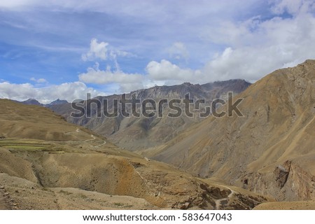 look into the distance on sand mountains and green fields