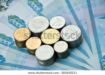 all kinds of russian coins in stacks on the one-thousand rubles banknotes. russian money for backgrounds and illustrations