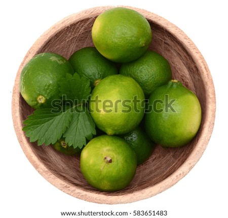 Limes in wooden bowl, top view