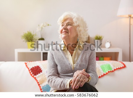 Happy elderly woman daydreaming 