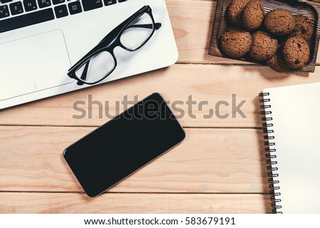 Office workspace, Office supplies with laptop, notepad, pencil and smartphone on wood table.Vintage retro picture style