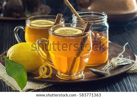 Two Glasses of Steaming Hot Lemon Spiced Tea or Hot Toddies for a Cold Winter's Day Royalty-Free Stock Photo #583771363