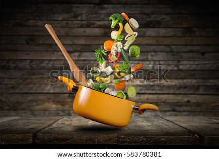 Fresh vegetables flying into a pot, placed on wooden planks
